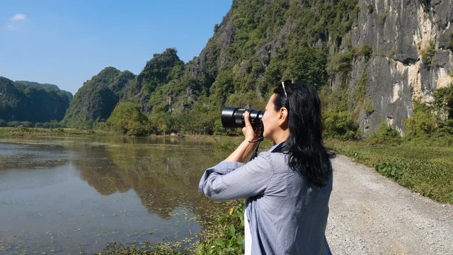 Attractive woman taking pictures of beautiful views at wetlands in Vietnam.