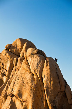 A man climbs Toe Jam 5.7 on the east face of the Old Woman Rock in the Hidden Valley Campground at Joshua Tree.       