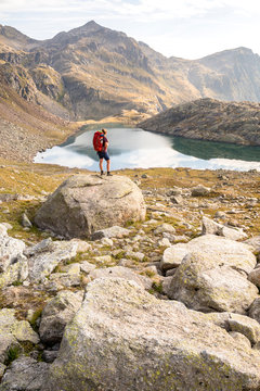 Spronser Lakes Hike, South Tyrol, Italy: A female hiker above the "long lake" (Langsee / Lago Lungo), one of the Spronser Lakes.