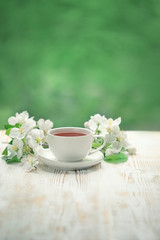 Cup of tea and white flowers on white table. beautiful spring composition, Tea party. copy space