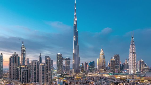 Dubai Downtown skyline day to night transition timelapse with Burj Khalifa and other towers paniramic view from the top in Dubai, United Arab Emirates. Traditional and modern buildings. Traffic on
