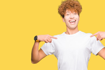 Young handsome man with afro hair wearing casual white t-shirt looking confident with smile on...
