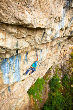 A man whips out some awesome english on Isla de los Locos (5.13c) at Natural Bridge State Park.