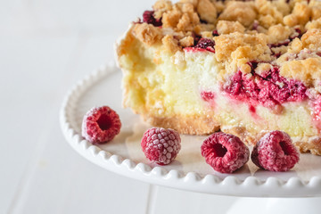 Shortcrust raspberries pie with crumble on white background.