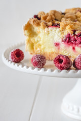 Shortcrust raspberries pie with crumble on white background.