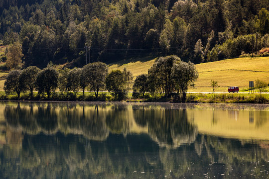 Oppstrynsvatnet Lake, Stryn, Nordfjord, Norway: An old Volkswagen Bully van on a road driving along the lake.