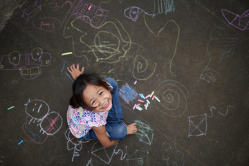 Asian girl drawing with chalk