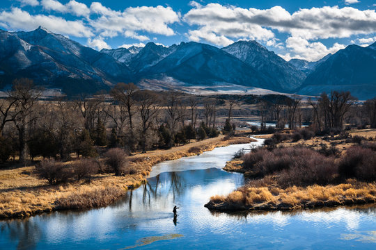 A man fly fishes in a spring creek in Paradise Valley, Montana on a beautiful wintry day.    
