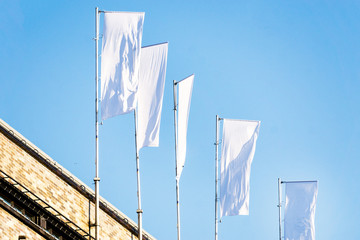 A lot of white flags against the blue sky hanging on the mast, copy space