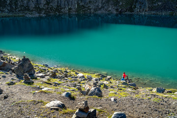 Mother and son at a turquoise mountain lake in the alps on a sunny day