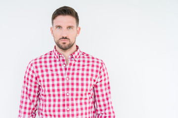 Fototapeta premium Young handsome man wearing shirt over isolated background Relaxed with serious expression on face. Simple and natural looking at the camera.