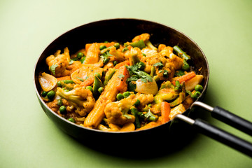 Mix vegetable curry - Indian main course recipe contains Carrots, cauliflower, green peas and beans, baby corn, capsicum and paneer/cottage cheese with traditional masala and curry, selective focus