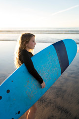 Girl holding surfboard at beach