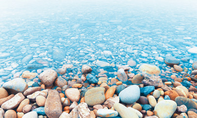 Abstract water and nature background.River stones or pebbles on the river shore and water.