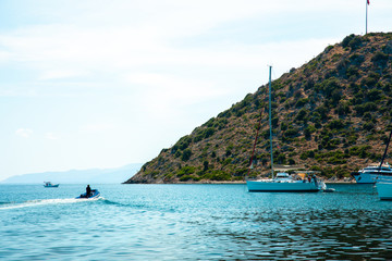 View of the Marina, sailing boats and yachts in Bodrum town or city of Turkey. Shore and coast of Aegean Sea with yachts in Gumusluk, Bodrum Marina