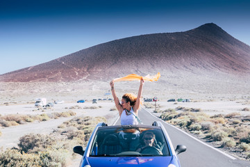 Freedom and travel concept for independent adult caucasian women together with convertible car - people traveling and enjoying tie friendship - drive and road concept © simona