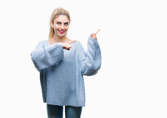 Young beautiful blonde and blue eyes woman wearing winter sweater over isolated background smiling and looking at the camera pointing with two hands and fingers to the side.