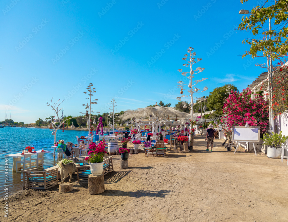 Wall mural view of restaurant or cafe and bougainvillea flowers on beach in gumusluk, bodrum city of turkey. ae