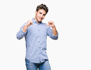 Young handsome business man over isolated background looking confident with smile on face, pointing...
