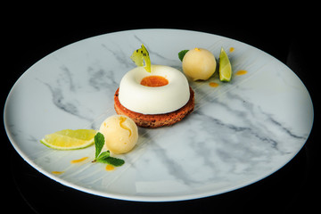 white mini mousse cake with ice cream and sliced limes