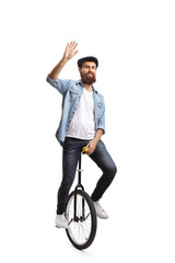 Man riding a unicycle and waving at the camera © Ljupco Smokovski
