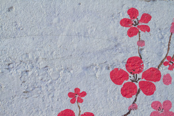 Abstract cherry blossoms in spring bloom on a very rough concrete textured surface.