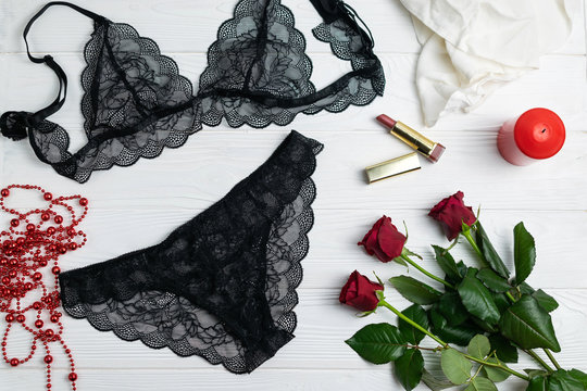 Black lace elegant lingerie composition with red roses and candle