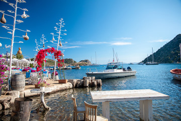 View of the Gumusluk, Bodrum Marina, sailing boats and yachts in Bodrum town, city of Turkey. Shore and coast of Aegean Sea with yachts and boats