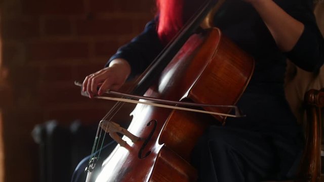 A woman emotionally playing the cello