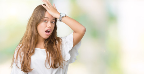 Naklejka premium Young beautiful brunette business woman over isolated background surprised with hand on head for mistake, remember error. Forgot, bad memory concept.