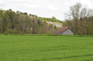 landscape with wooden barn and limestone rocks