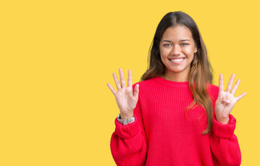 Young beautiful brunette woman wearing red winter sweater over isolated background showing and pointing up with fingers number nine while smiling confident and happy.