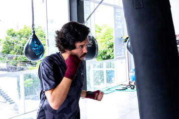 hombre entrenando con guantes  sacos de entrenamiento en gimnasio