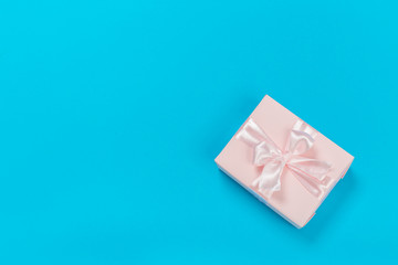 beautiful gift boxes wrapped in paper with gold and pink ribbon on a blue surface. Top view