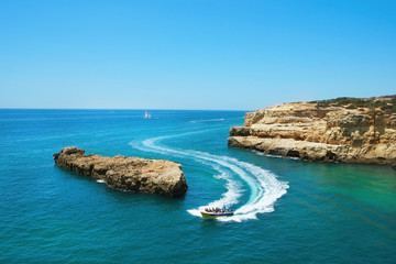 Fototapeta premium Rocky beaches with cliffs somwhere, somwhere in Algarve, Portugal. Atlantic ocean shore background. Copy space for text.