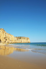 Fototapeta na wymiar Rocky beaches with cliffs somwhere, somwhere in Algarve, Portugal. Atlantic ocean shore background. Copy space for text.