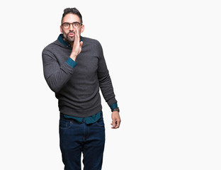 Fototapeta premium Young handsome man wearing glasses over isolated background hand on mouth telling secret rumor, whispering malicious talk conversation