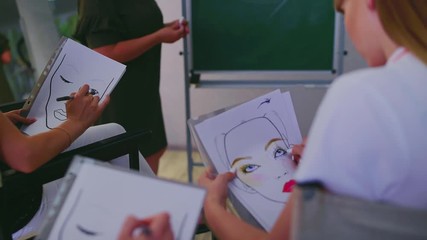 Makeup training. Teacher visagiste teaches students to applying makeup on the eyes at master class in beauty school