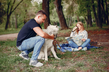 Fototapeta premium Couple in a forest. Pair playing with a cute dog