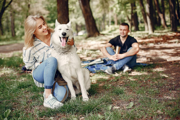 Couple in a forest. Pair playing with a cute dog