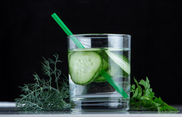 Cucumber water, cleansing water to detoxify the body and quench thirst on a black background.