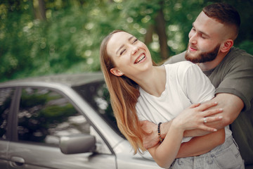 Obraz premium Couple in a forest. Man in a green t-shirt. Pair near car