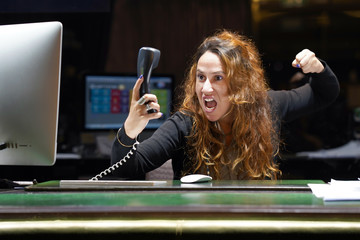A woman-reception swears with the client of the hotel by phone. A woman is shouting into the...