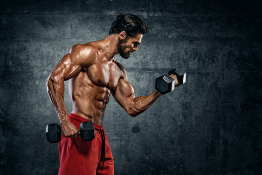 Bodybuilder Exercise With Dumbbells. Performing Dumbbell Curls for biceps