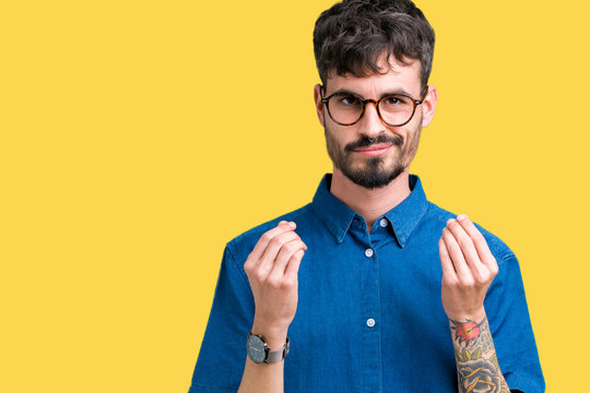 Young handsome man wearing glasses over isolated background Doing money gesture with hand, asking for salary payment, millionaire business