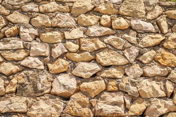 Masonry wall of stones with irregular pattern texture background