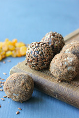 Homemade healthy raw vegan sweet balls with nuts,raisins, dates, cocoa and flax seeds. Healthy vegan food concept. Gray background.
