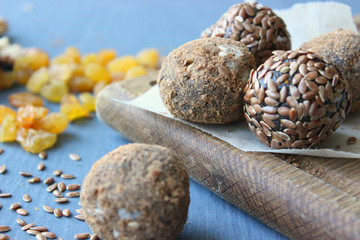 Homemade healthy raw vegan sweet balls with nuts,raisins, dates, cocoa and flax seeds. Healthy vegan food concept. Gray background.