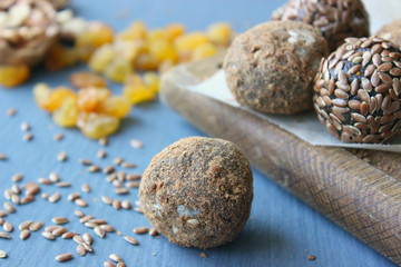 Obraz na płótnie Canvas Homemade healthy raw vegan sweet balls with nuts,raisins, dates, cocoa and flax seeds. Healthy vegan food concept. Gray background.