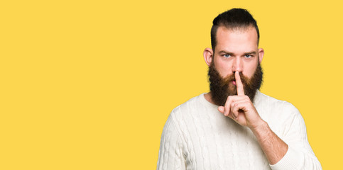 Fototapeta premium Young hipster man wearing winter sweater asking to be quiet with finger on lips. Silence and secret concept.